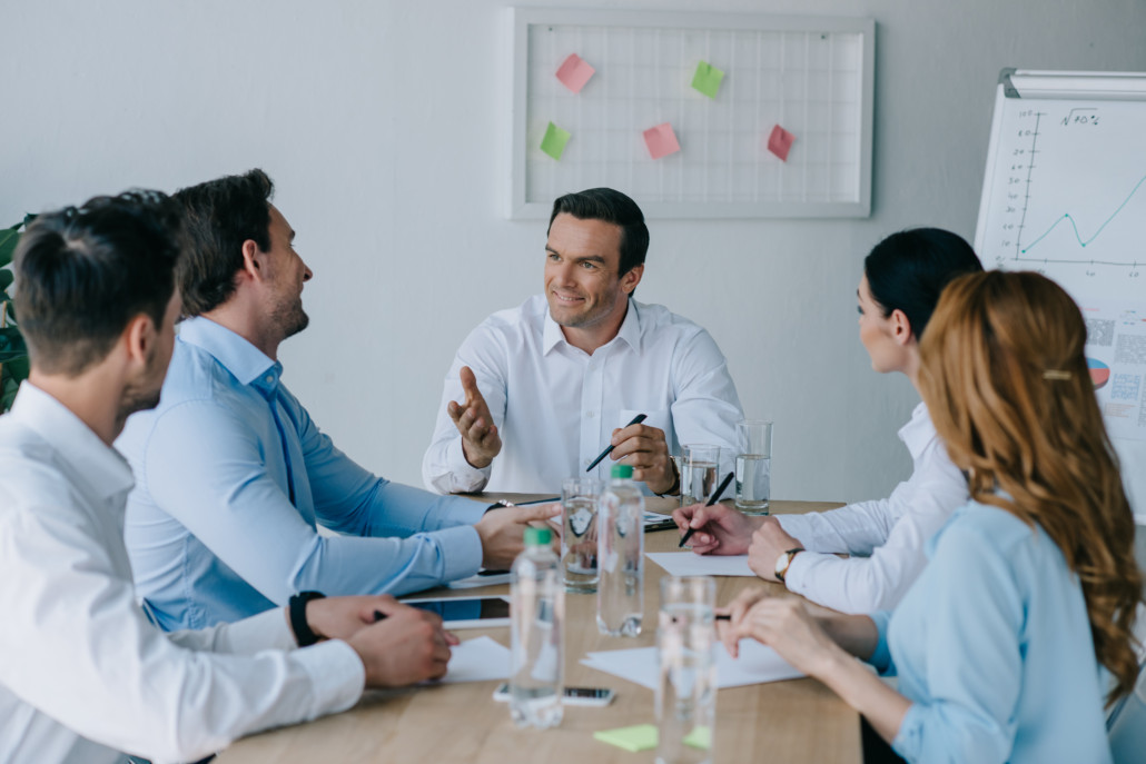 Group of business professionals sitting around a conference table.